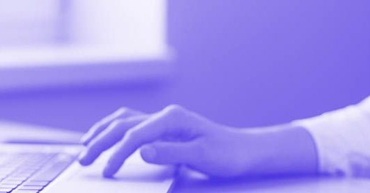 A woman typing on a laptop