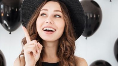 A woman surrounded by black balloons