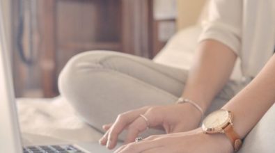 A woman using her laptop on a bed