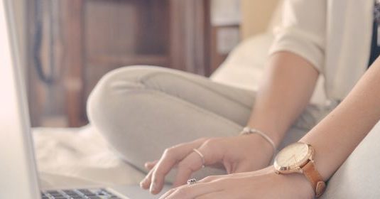 A woman using her laptop on a bed